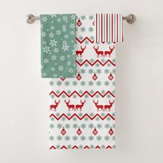 two towels hanging on a towel rack with reindeers and snowflakes printed on them