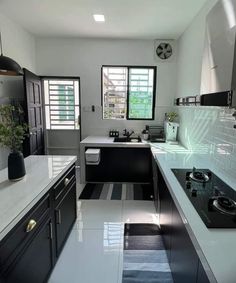 a kitchen with black and white tile flooring and counter tops, along with a stove top oven