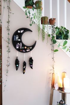 there is a wall decoration with shoes hanging on it and plants growing up the stairs