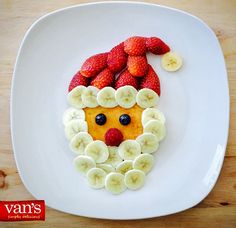 a white plate topped with fruit and a face made out of bananas, strawberries and kiwis