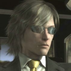 a man in a suit and tie with sunglasses on his face looking at the camera