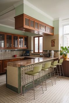 a kitchen with an island and bar stools in front of the counter top area