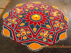 an intricately decorated floor with candles in the shape of a flower and leaves on it