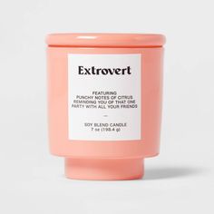 a pink candle that says extrovert on it's side, with the label