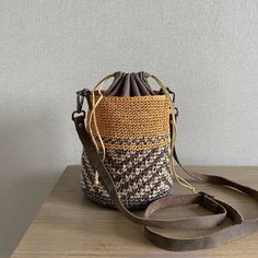 a purse sitting on top of a table next to a brown and white bag with handles