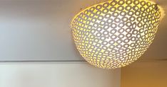 a light that is hanging from the ceiling in a room with white walls and flooring