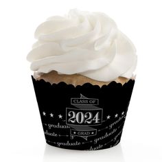 a cupcake with white frosting and graduation decorations on it's wrapper