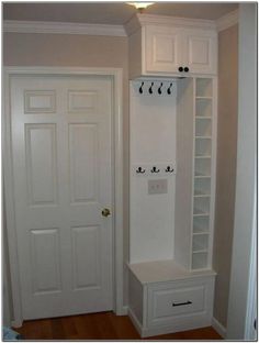 a white coat rack in the corner of a room next to a door and closet