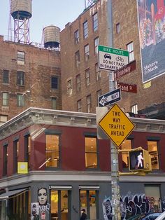 a street sign in front of a building with graffiti on the walls and around it