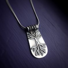 Silver Tree of Life Necklace on purple background. Necklace has roots and branches that go over the bail. Pendants with meaning handmade Vermont. Symbolic Tree Of Life Sterling Silver Jewelry, Symbolic Sterling Silver Tree Of Life Jewelry, Spiritual Sterling Silver Jewelry With Tree Of Life, Sterling Silver Tree Of Life Nature-inspired Jewelry, Spiritual Tree Of Life Sterling Silver Necklace, Unique Sterling Silver Tree Of Life Necklace, Inner Wisdom, Jewelry Pendants, Silver Tree