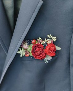 a man wearing a blue suit with red flowers on it's lapel pin