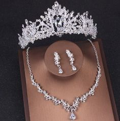 a tiara and jewelry set sitting on top of a table