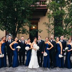 a large group of people in formal wear posing for a photo on their wedding day