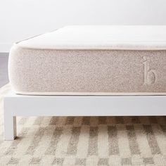 a white bed frame sitting on top of a rug