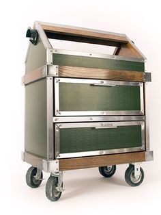 a metal cart with three drawers and wheels on the bottom, against a white background