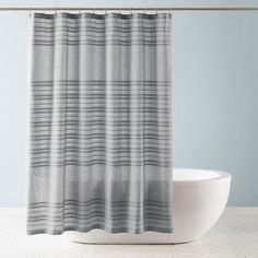 a bath tub sitting next to a shower curtain