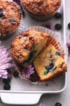 blueberry muffins on a white tray with purple flowers