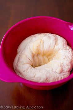 a peeled banana in a pink bowl on a table