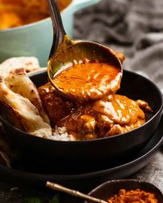 a bowl filled with meat and sauce on top of a table