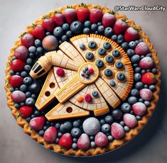 a star wars themed pie with berries and blueberries in the shape of a millennium falcon