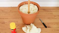 a potted plant sitting on top of a hard wood floor next to a knife