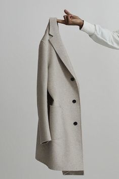 a man holding onto a coat on a hanger