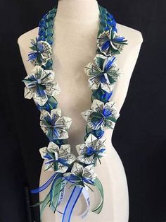 a white mannequin with blue ribbon and flowers on it's neckline