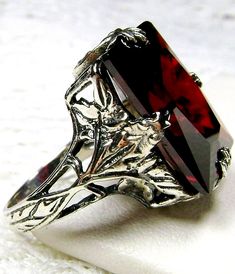 Garnet CZ Ring Description  GL Design#15 Made To Order Inspired by the Art Deco movement, I now offer this stunning Antique reproduction in antiqued sterling silver. This lovely ring is set with a 10ct flawless garnet CZ gemstone. The inside of the band is hallmarked 925. This rectangle-cut red garnet CZ is 16mm (5/8th of an inch) by 12mm (1/2 inch) in size. Notice the beautiful floral leaf design of the silver filigree setting and band... simply stunning. This is an exquisite rendition of an an Leaf Filigree, Star Garnet, Antique Filigree, Gemstone Art, Gems Art, Gothic Rings, Lovely Ring, Filigree Ring, Cz Ring