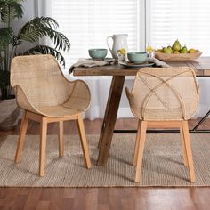 two wicker chairs sitting at a table with plates and bowls of fruit on it