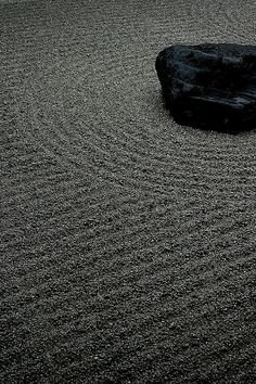 a rock sitting on top of a sandy beach