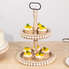 three tiered cake stand with cupcakes on it