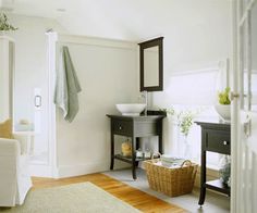 a bathroom with white walls and wooden floors