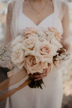 a woman holding a bouquet of flowers in her hands