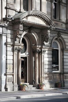 an old building with ornate architecture on the front and side of it's entrance