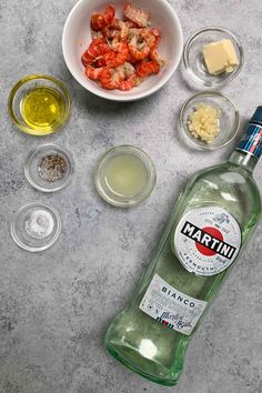 ingredients to make shrimp salad laid out on a counter top next to a bottle of martini