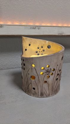 a metal container with holes and flowers on it