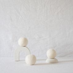 two small white balls sitting next to each other on top of a white table cloth