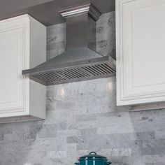 a stove top oven sitting inside of a kitchen next to white cabinets and counter tops