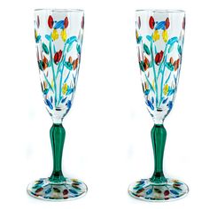 two glass goblets decorated with colorful flowers and leaves, one on each side