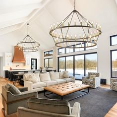 a living room filled with furniture and a large chandelier hanging from the ceiling