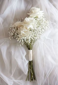 a bouquet of white flowers sitting on top of a bed