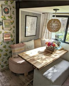 a dining room table and bench in front of a window with pictures on the wall