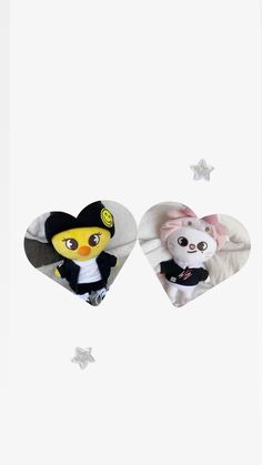 two stuffed animals in the shape of hearts with stars around them on a white background