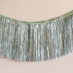 a green fringe hanging from the side of a wall