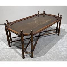 an old wooden table with metal legs and a glass top on the bottom is shown