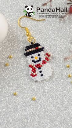 a small beaded snowman ornament hanging from a christmas tree