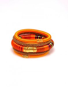 three orange and brown bracelets with gold accents