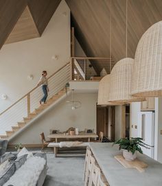 a man is walking up the stairs in a house with white walls and wooden ceilings