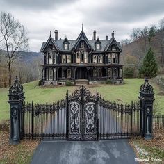 an old fashioned house with wrought iron gates in the front yard and driveway leading up to it