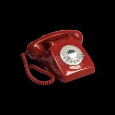 an old fashioned red telephone on a black background